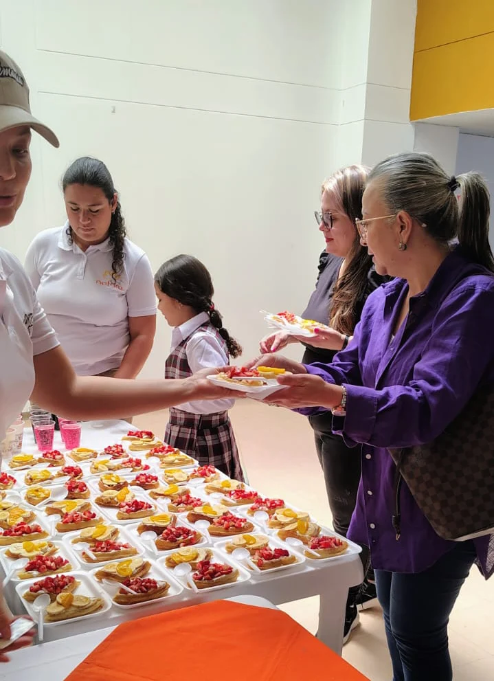 Equipo sirviendo waffles con frutas en un evento