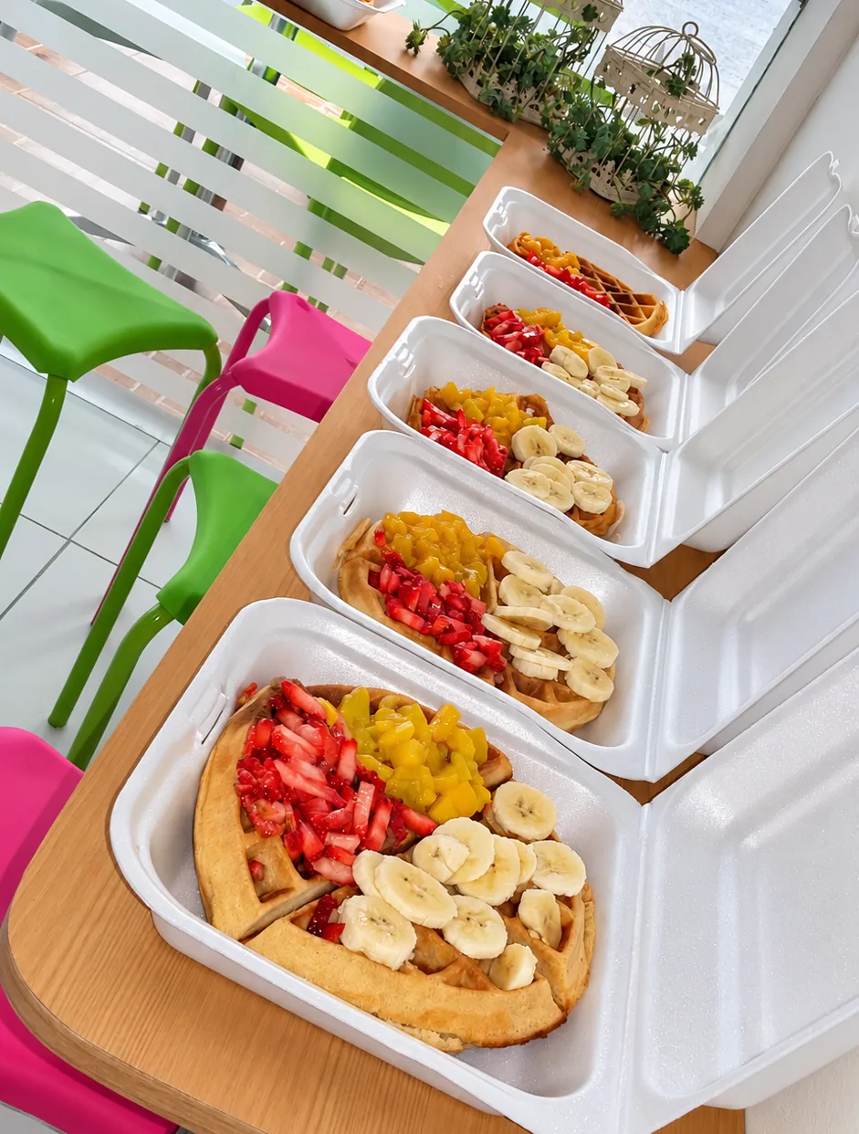 Waffles con frutas en cajas junto a la ventana